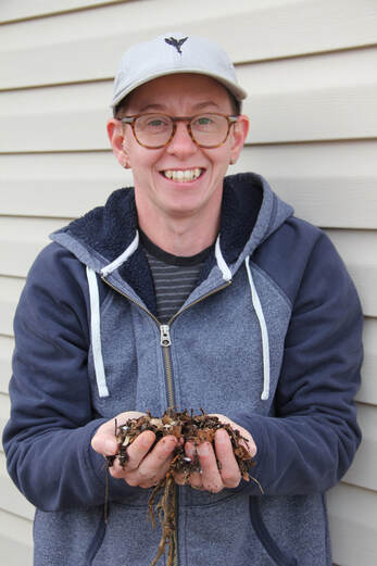 worm farmer holding handful of worms and worm bedding